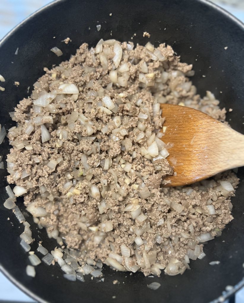 cooked ground beef, onions, and garlic in pot