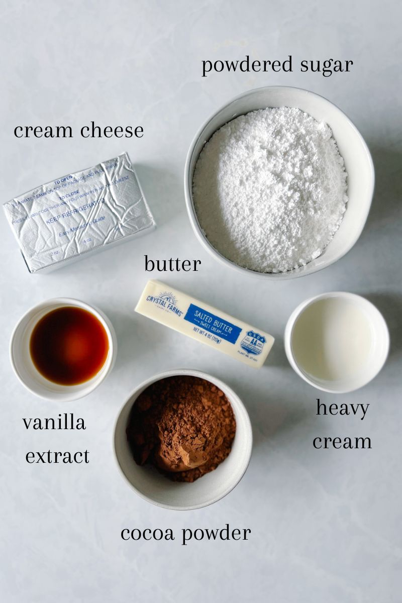 Ingredients needed for chocolate cream cheese frosting: powdered sugar, cream cheese, butter, vanilla extract, cocoa powder, heavy cream.
