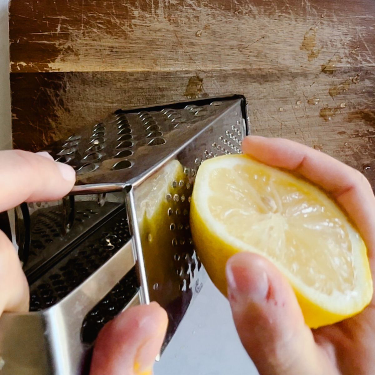 grating a lemon on cutting board.