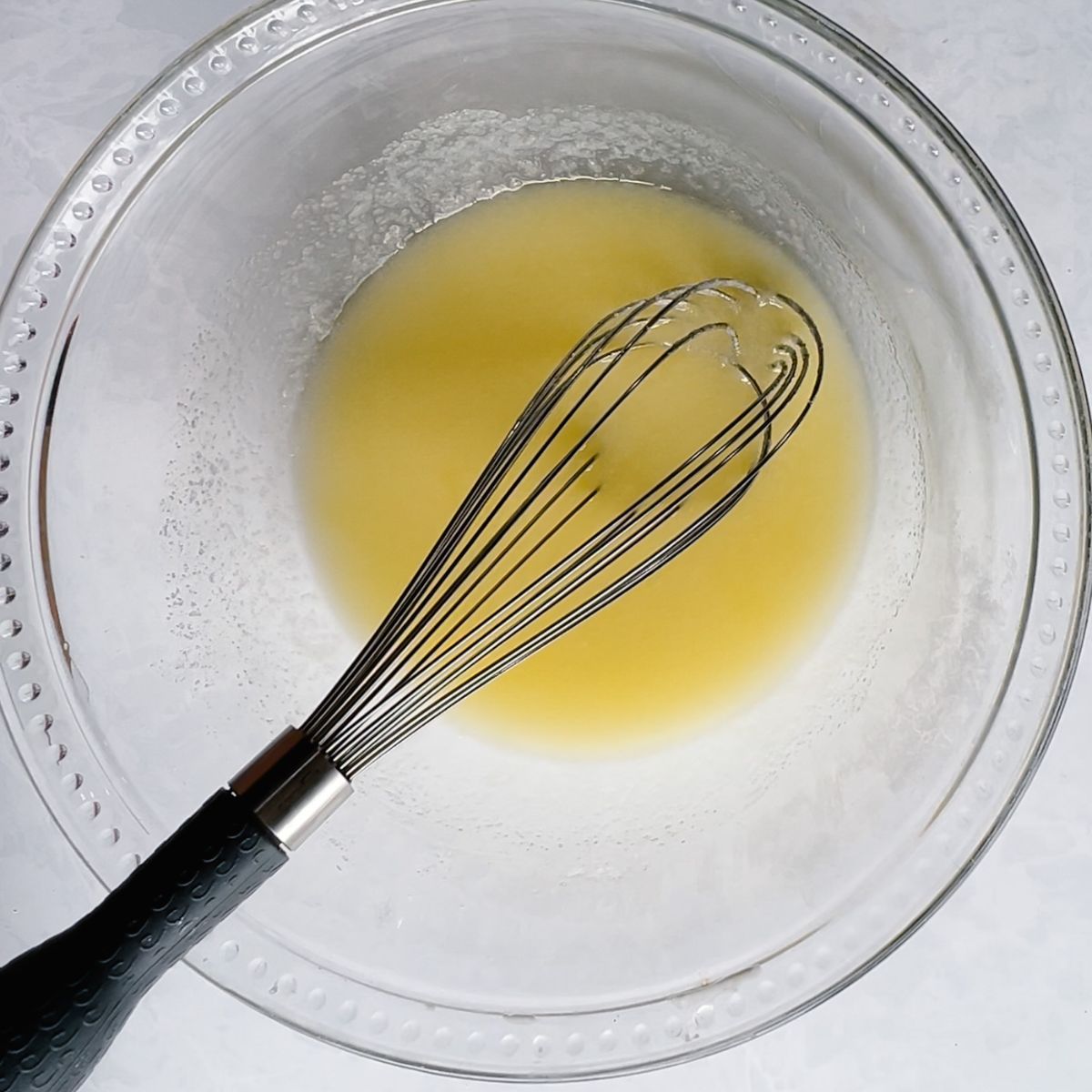 Melted butter, granulated sugar, and eggs whisked in a mixing bowl. 