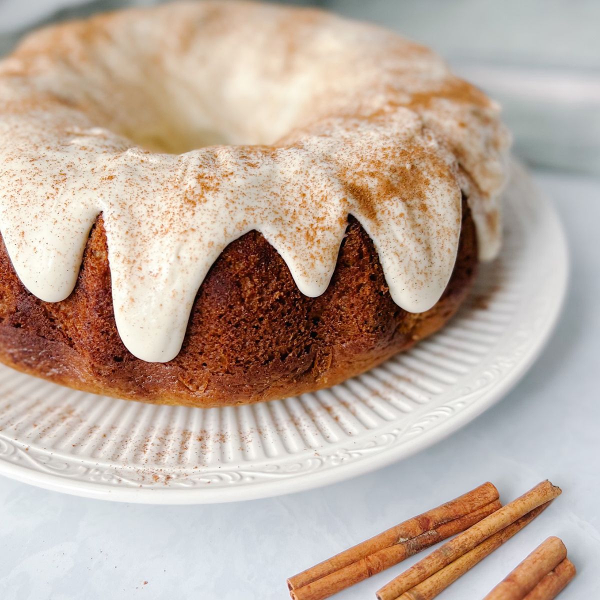 Spice bundt cake with caramel cream cheese frosting on a plate.