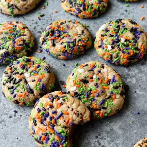 Brown butter sugar cookies with sprinkles. One cookie has a bite out of it.