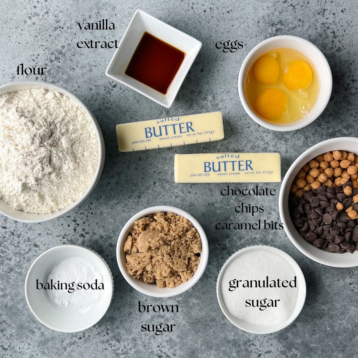 Ingredients needed for caramel chocolate chip cookies: flour, vanilla extract, eggs, butter, semi-sweet chocolate chips, caramel bits, granulated sugar, brown sugar, baking soda.