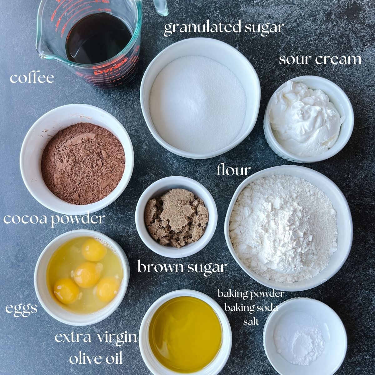 Ingredients shot for the chocolate pound cake. It includes: coffee, granulated sugar, sour cream, brown sugar, flour, cocoa powder, eggs, extra-virgin olive oil, baking powder, baking soda, and salt.