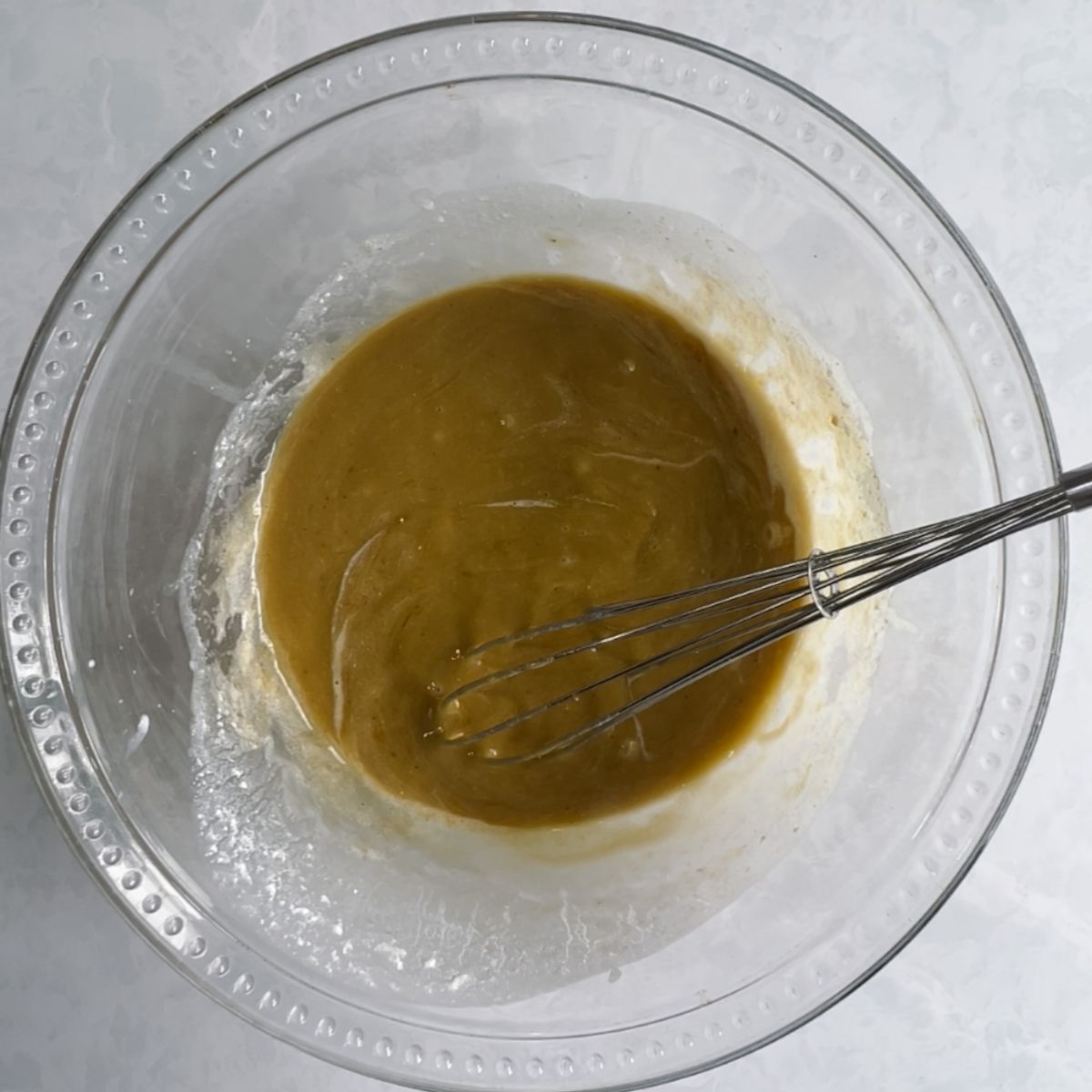 Tahini, olive oil, brown and white sugar, vanilla extract and eggs mixed together in a mixing bowl. 