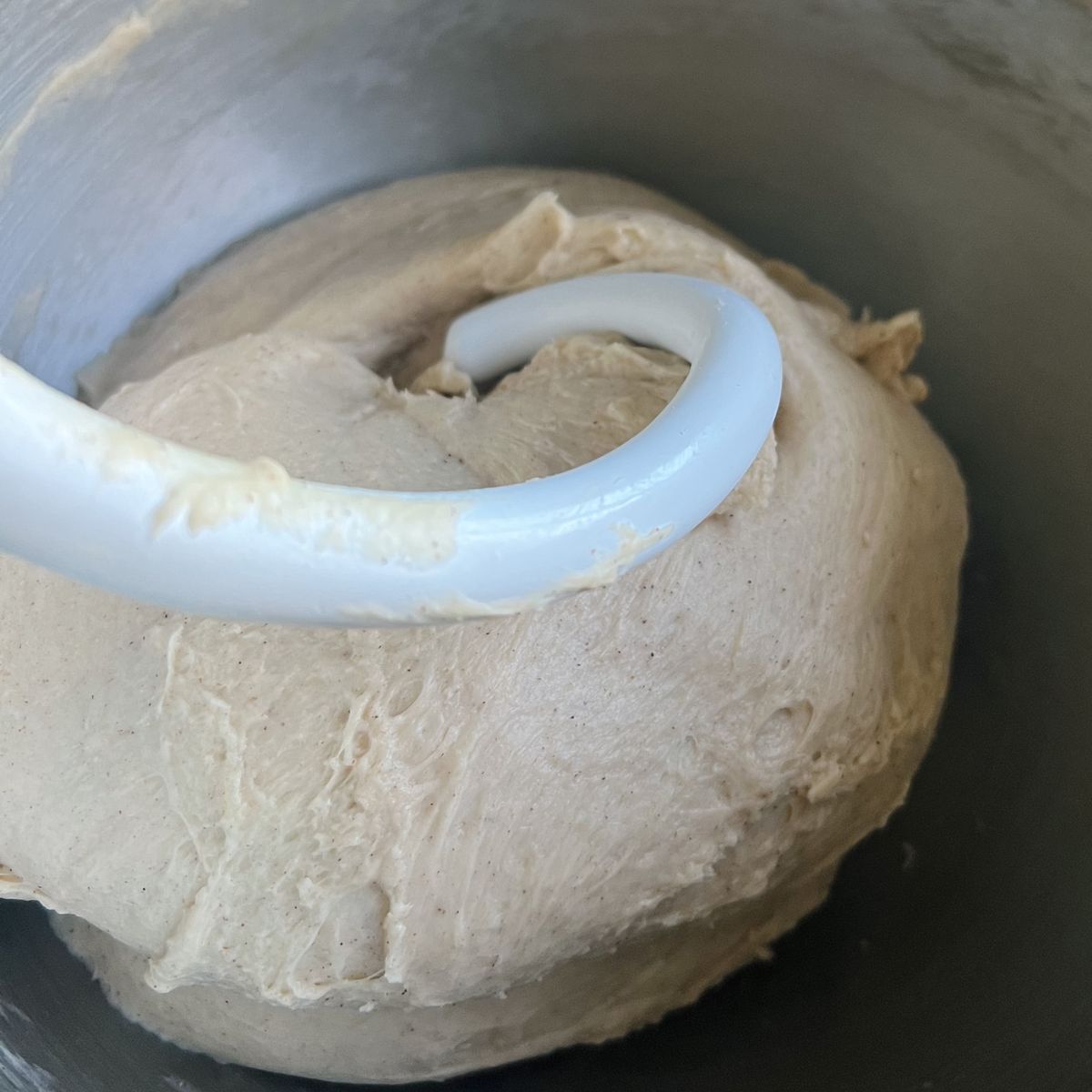 Dough being kneaded in the mixing bowl with a hook attachment.