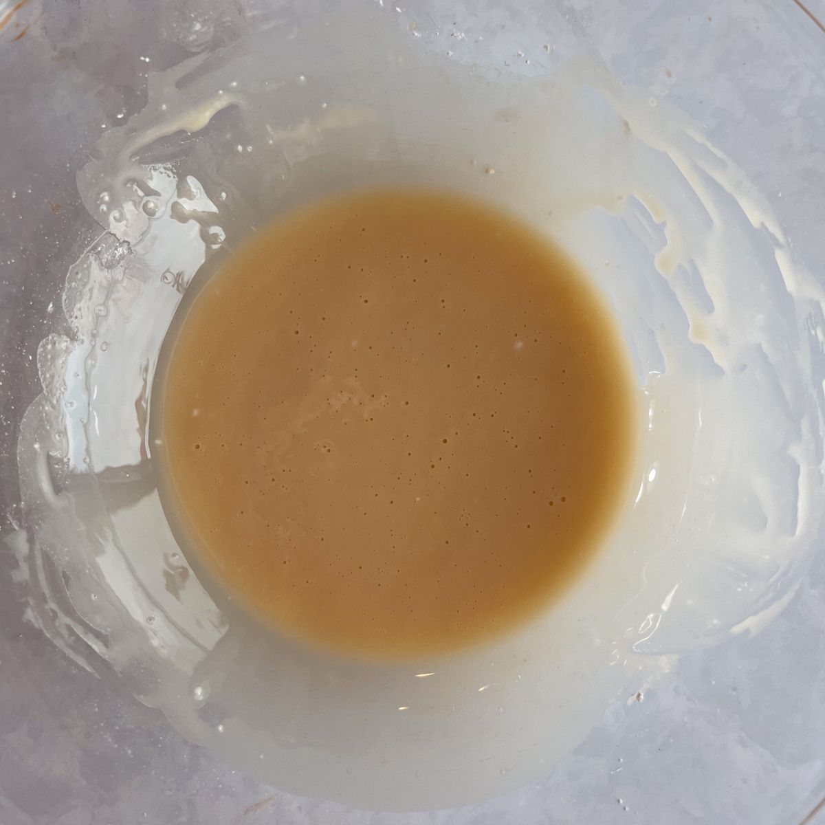 Orange glaze whisked together in a mixing bowl.
