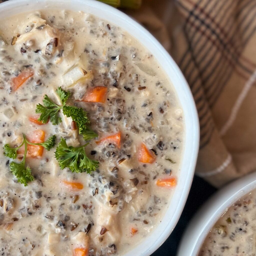Close up of creamy chicken wild rice soup topped with fresh parsley.