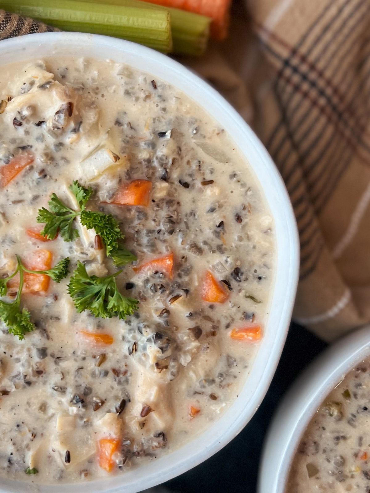 Bowl of creamy chicken wild rice soup topped with fresh parsley.