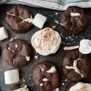 Hot cocoa cookies surrounded by marshmallows and crushed peppermint candy canes.