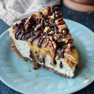 A slice of turtle cheesecake on a blue plate.