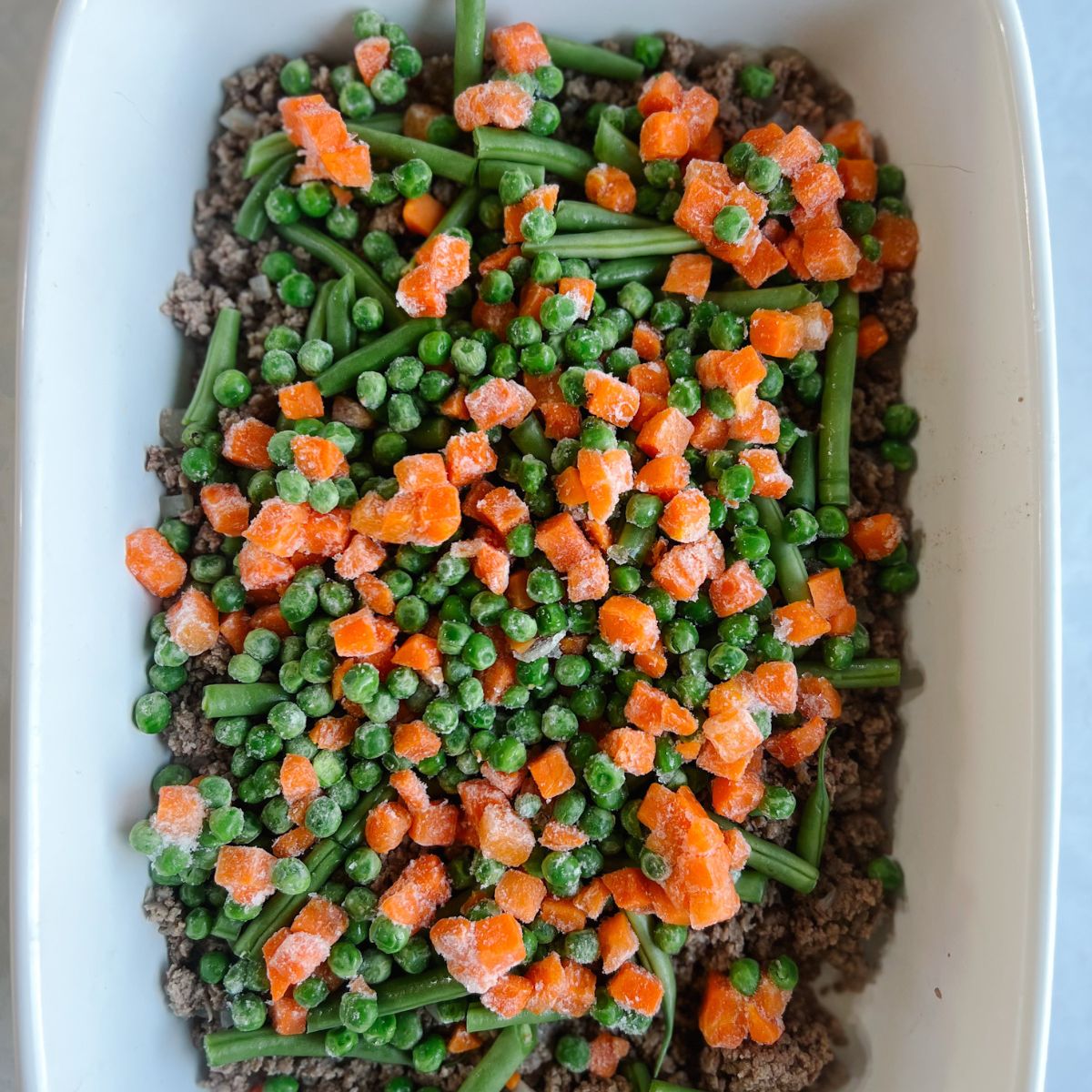 Casserole dish with ground beef and vegetables on top.