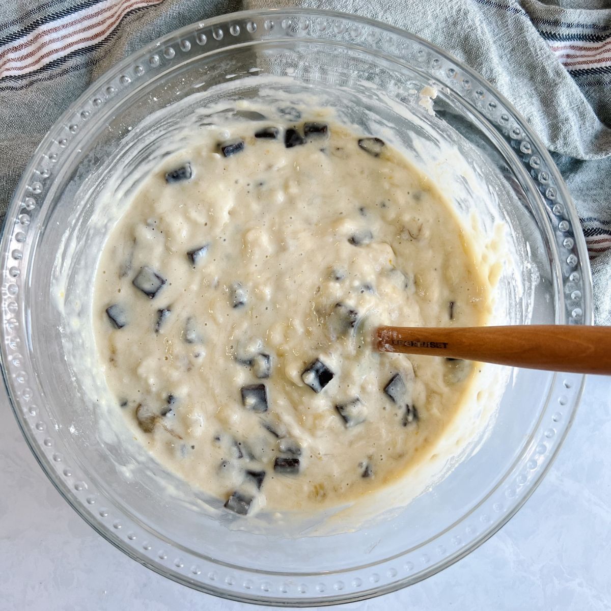Chocolate chunk banana bread batter with chocolate chunks added to the batter.