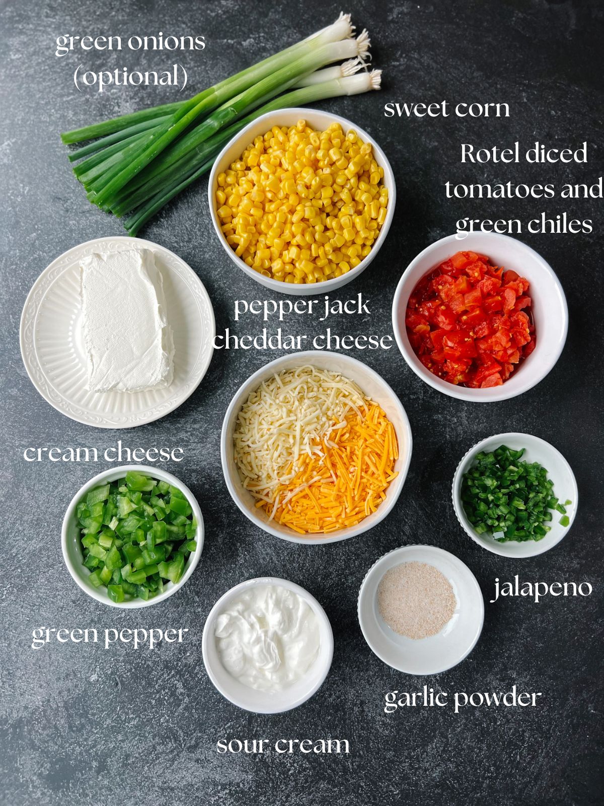 Ingredients for the cream cheese corn dip: green onions, sweet corn, Rotel diced tomatoes and green chiles, pepper jack and cheddar cheese, cream cheese, garlic powder, jalapeno, green pepper, sour cream.