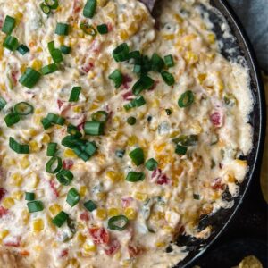 Close up of the cream cheese corn dip in a cast iron skillet.