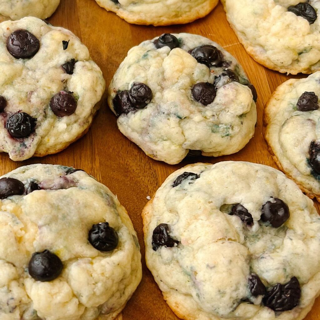 Close up picture of lemon blueberry cookies on a wooden cutting board.