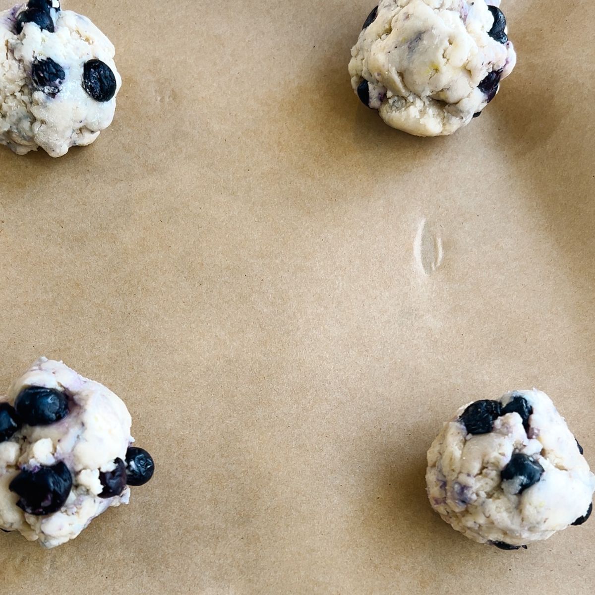 Step Four: lemon blueberry cookie dough balls on parchment paper lined baking sheet.