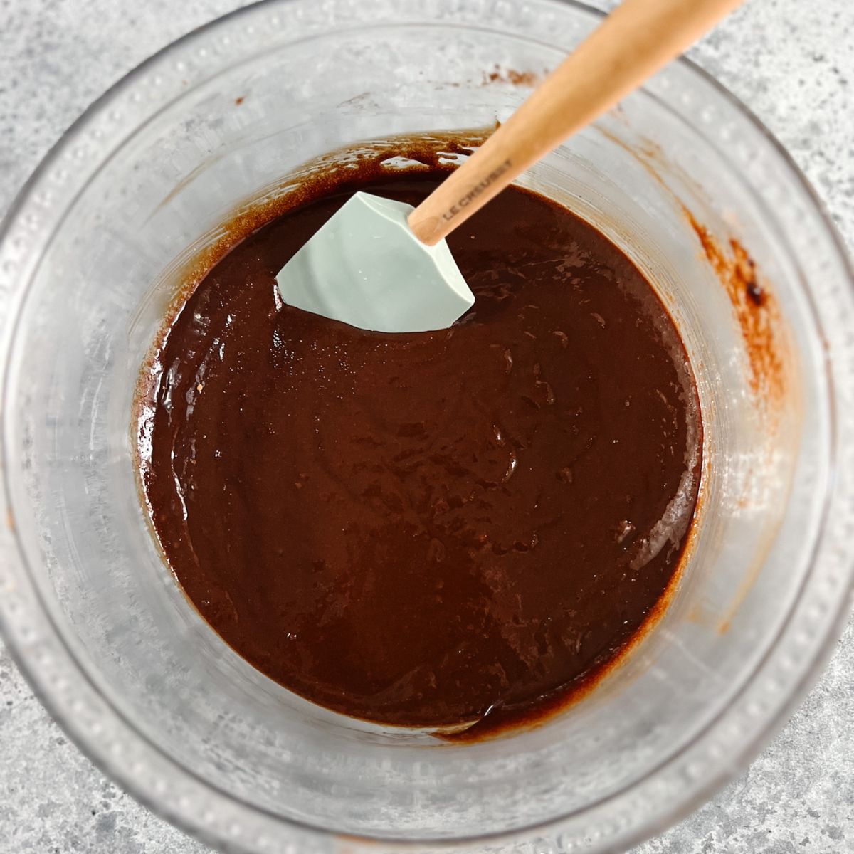 Wet ingredients added to the brownie batter in the mixing bowl. 