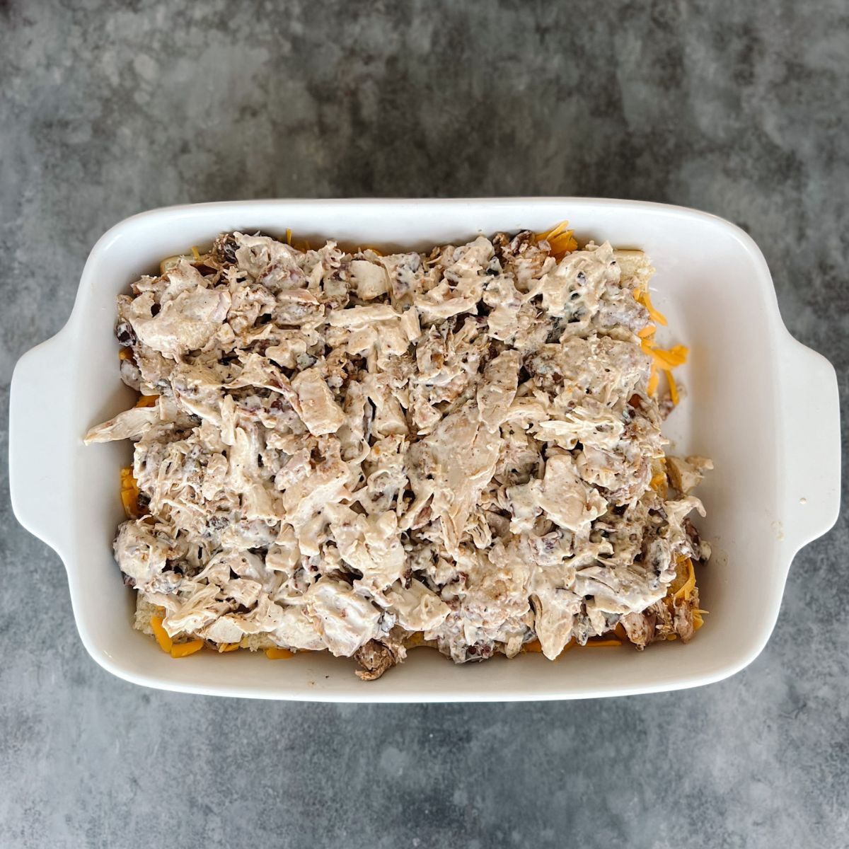 Chicken mixture on top of the shredded cheese.