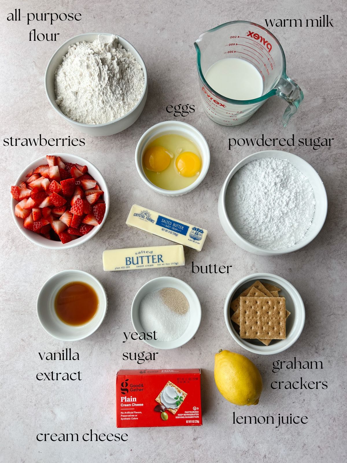 Ingredients for the strawberry cheesecake sweet rolls: warm milk, flour, eggs, powdered sugar, strawberries, butter, vanilla extract, yeast, sugar, graham crackers, cream cheese, lemon juice.