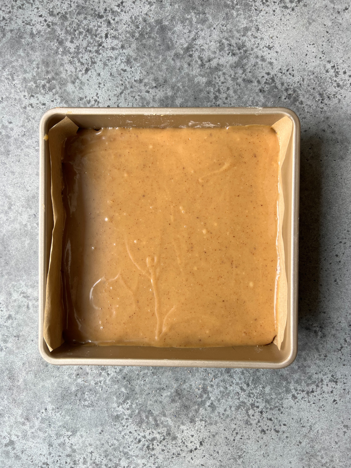 The baking pan with the caramel layer on top of the shortbread.