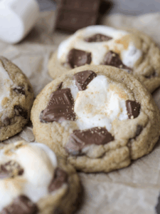 Closeup of a smores sourdough cookies with several in the background on parchment paper.