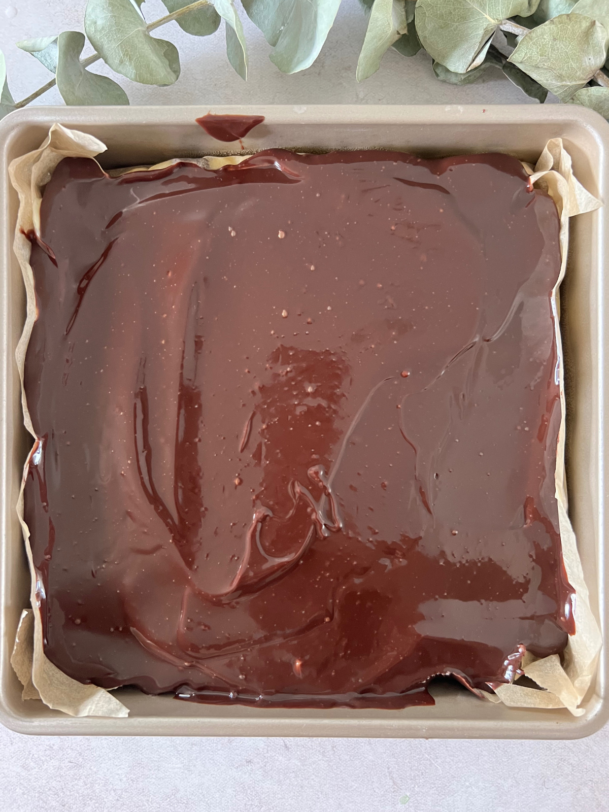 The brownies, vanilla custard, and chocolate ganache in the baking pan before it goes in the fridge to chill. 