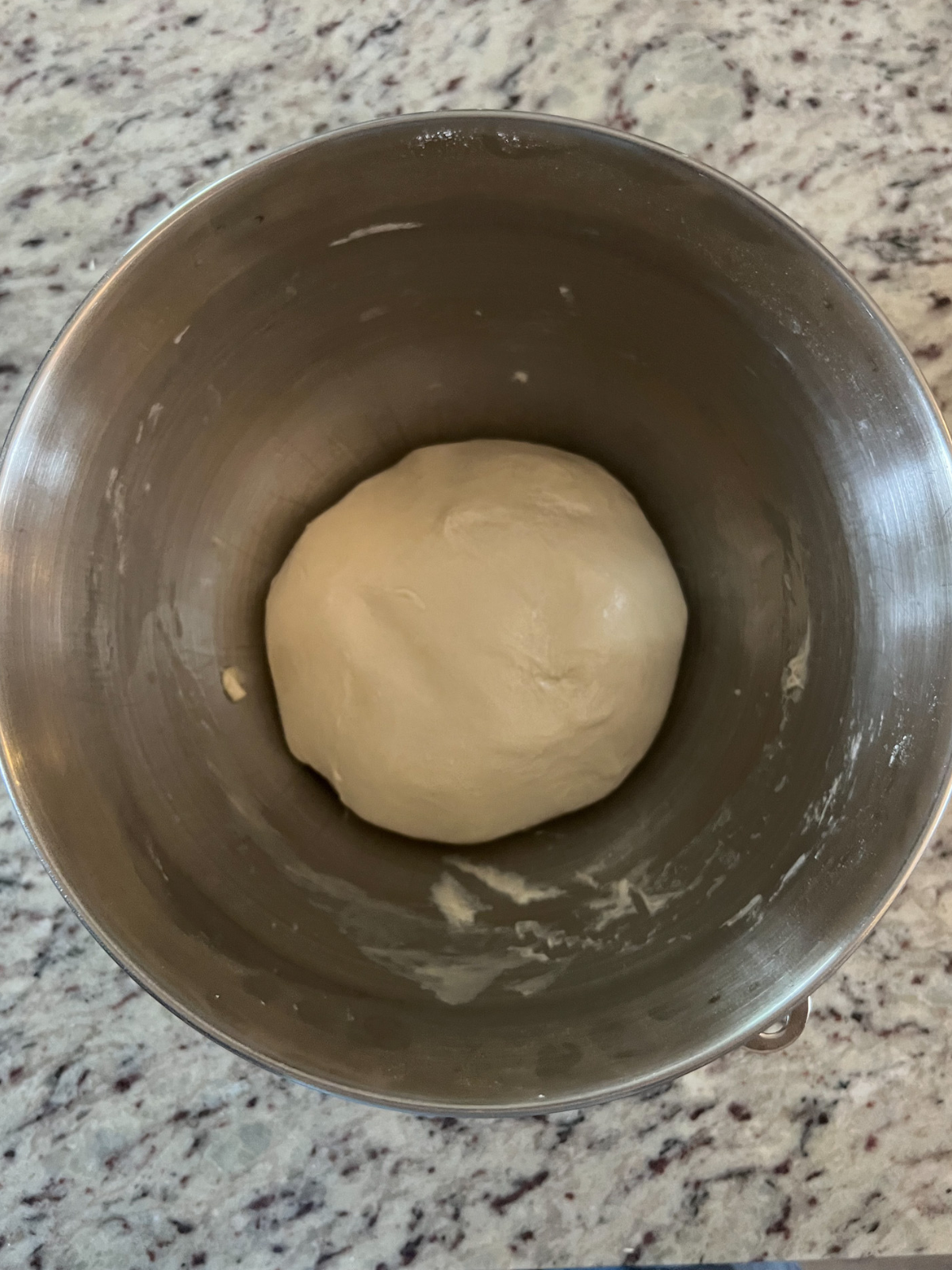The kneaded dough ball of sourdough bagel dough in a mixing bowl.