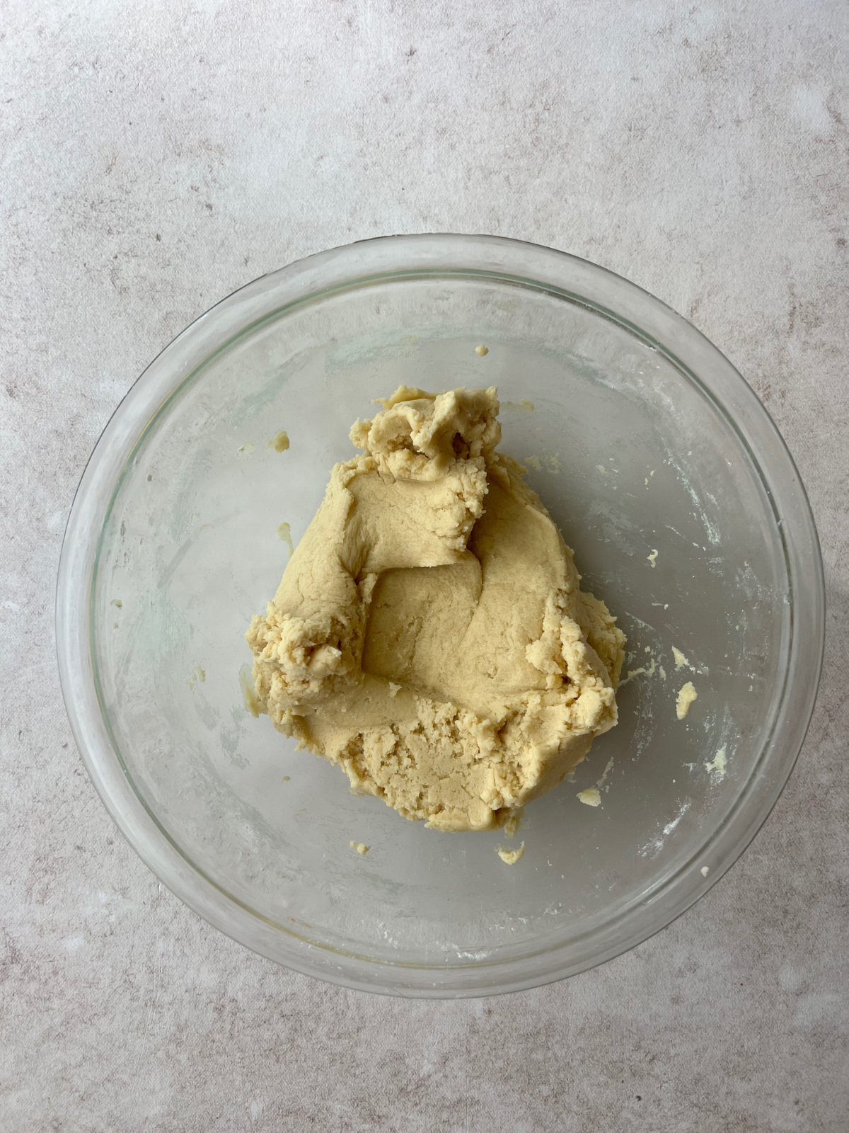 This is a glass mixing bowl with all of the cookie dough in a ball.