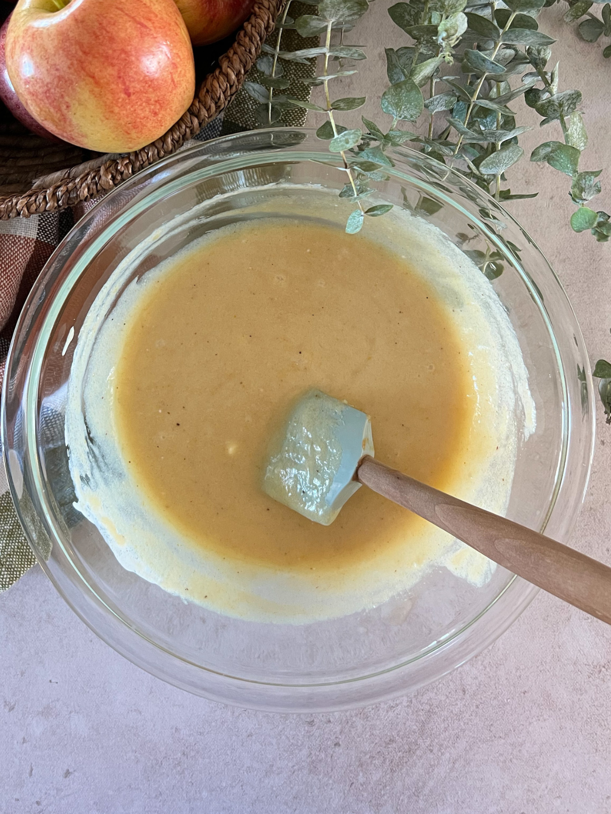 The wet ingredients for the brown butter apple streusel bread sit in a glass mixing bowl.