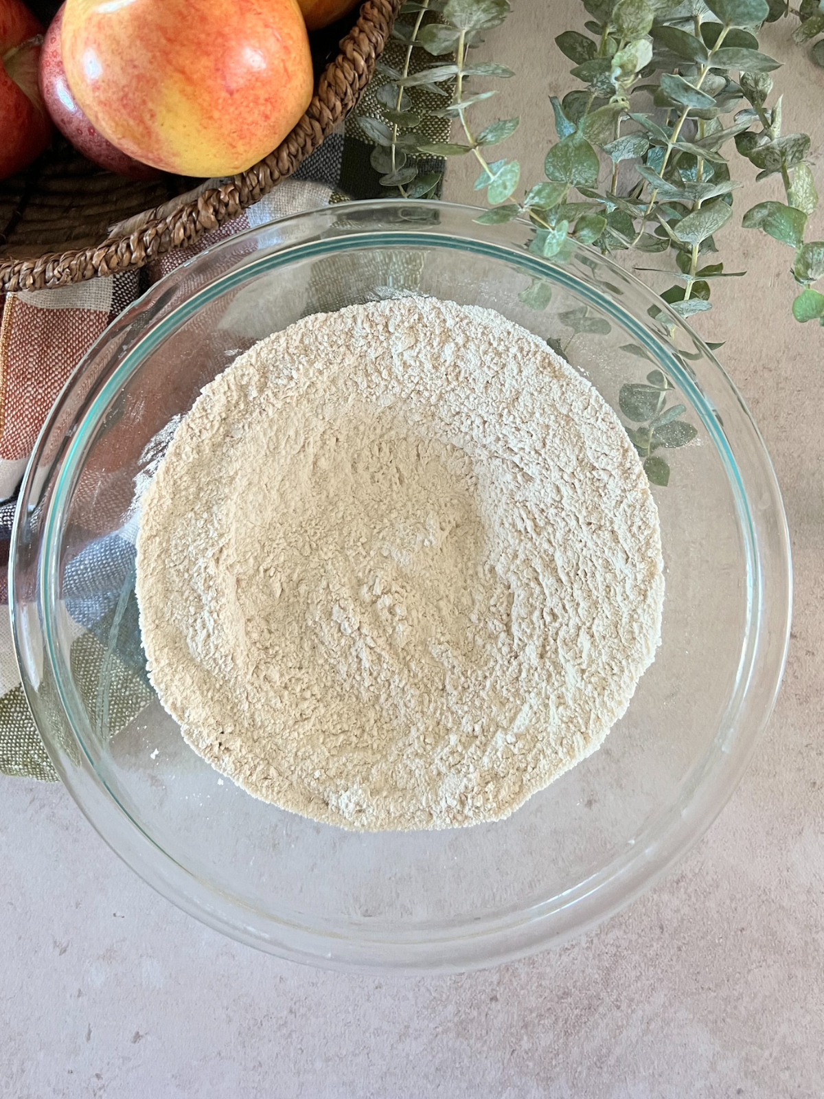 The dry ingredients for the browned butter apple streusel bread sit in a glass mixing bowl.