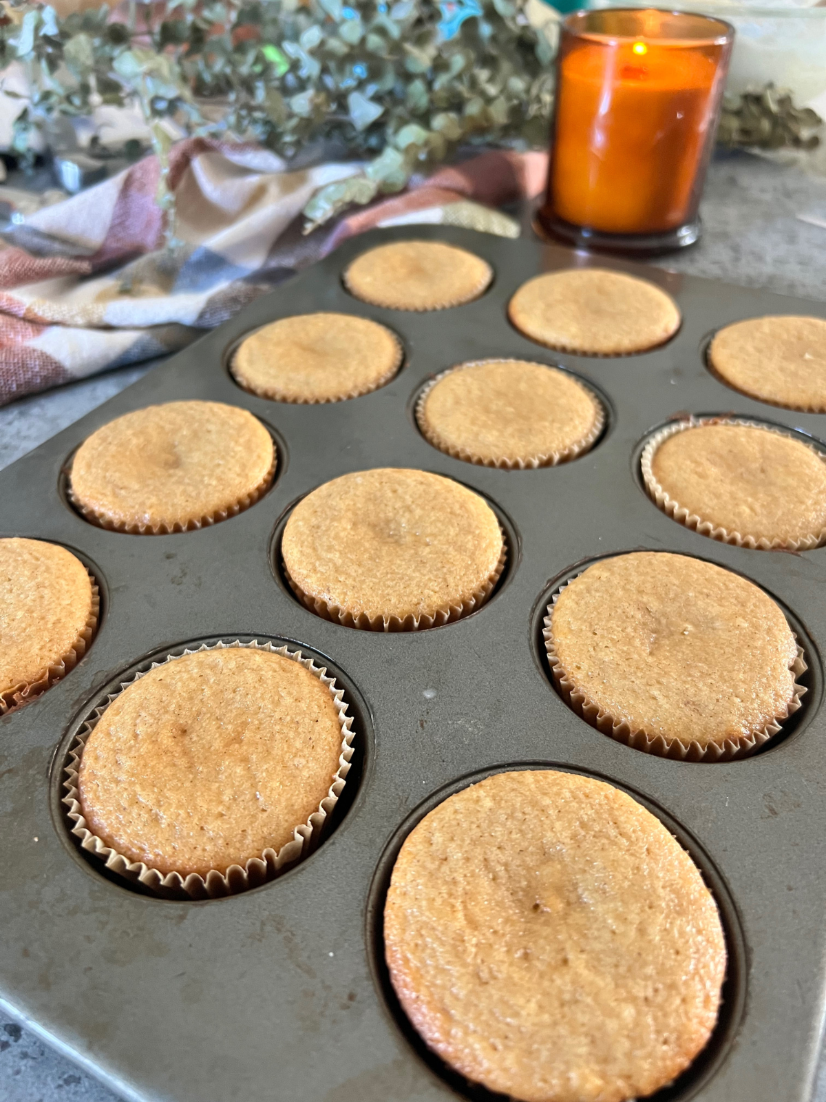 The baked cupcakes sit in the cupcake pan after being baked.