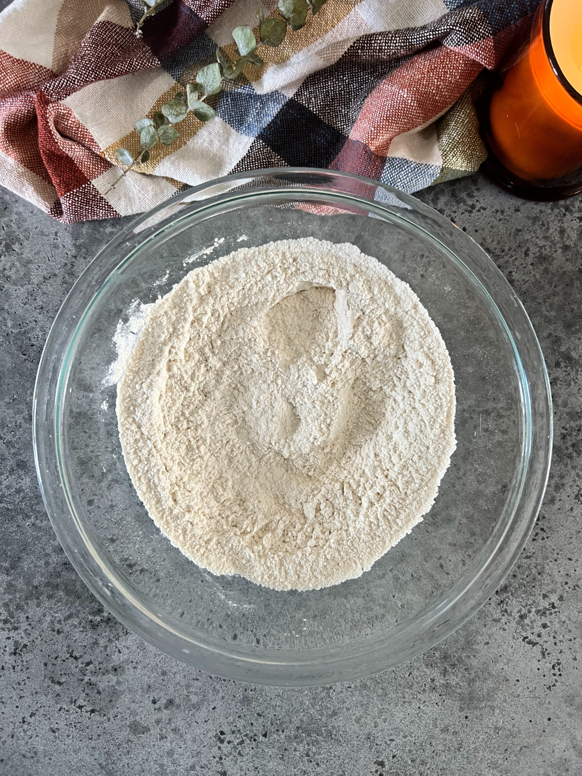 The dry ingredients for the brown butter cupcakes sit in a glass mixing bowl.