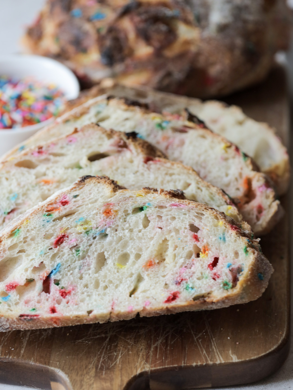 A closeup of four slices of sourdough funfetti bread. 