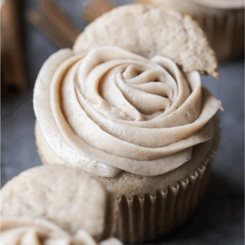 Closeup of one sourdough discard snickerdoodle cupcake with cinnamon cream cheese frosting piped on top.