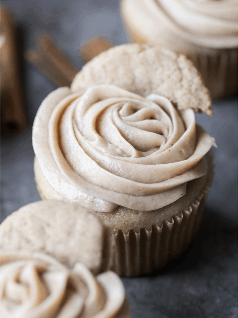 Closeup of one sourdough discard snickerdoodle cupcake with cinnamon cream cheese frosting piped on top.