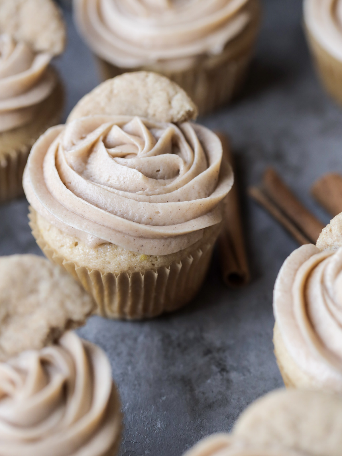 Several sourdough discard snickerdoodle cupcakes piped with cinnamon cream cheese frosting.