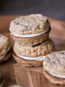 Two sourdough discard oatmeal cream pies stacked on each other with a couple other sourdough discard cookie sandwiches in the background.