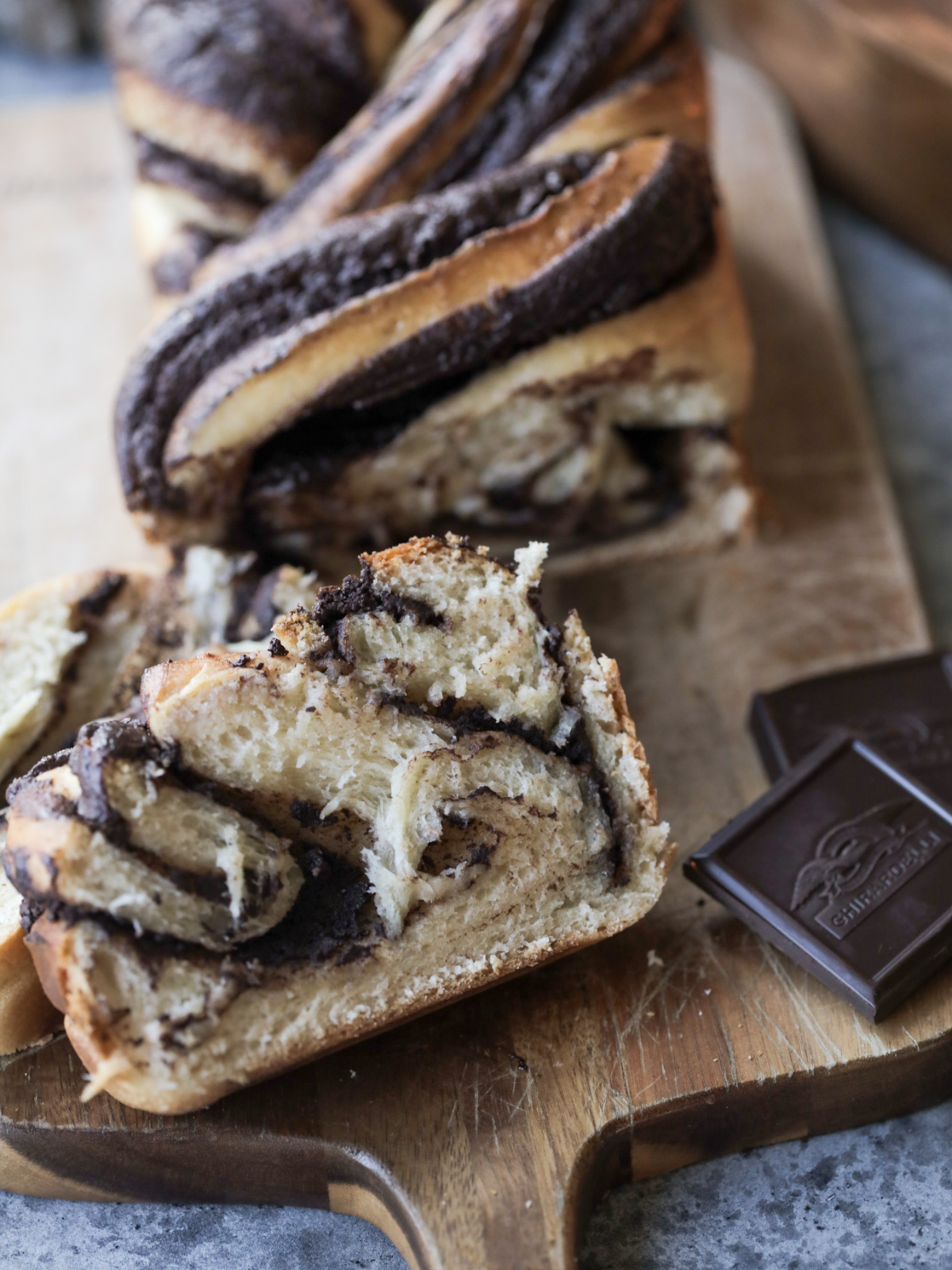 A loaf of sourdough chocolate babka with a couple slices sitting in front.