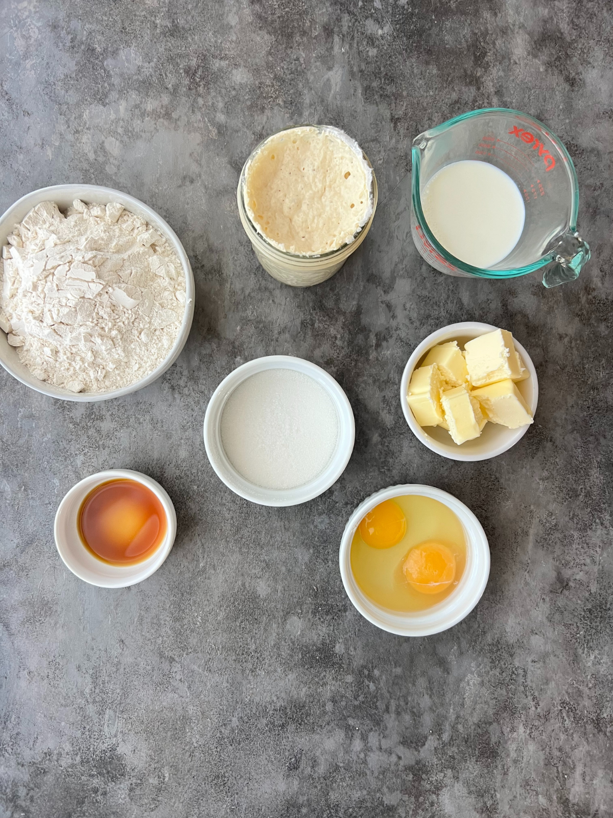 The ingredients needed for the dough to make the sourdough chocolate babka sit on a counter.