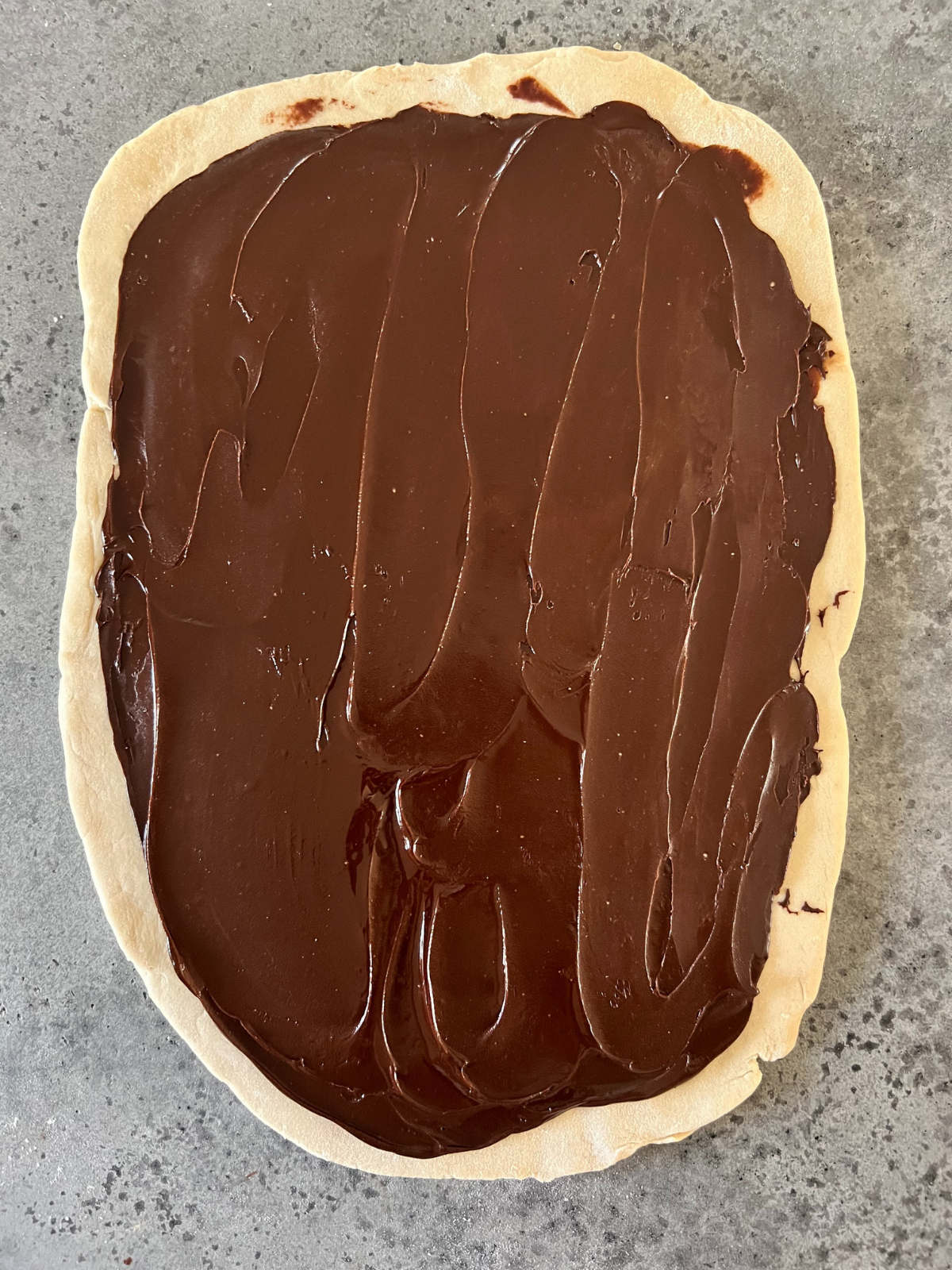 The chocolate filling is spread over the top of the rolled out babka dough.