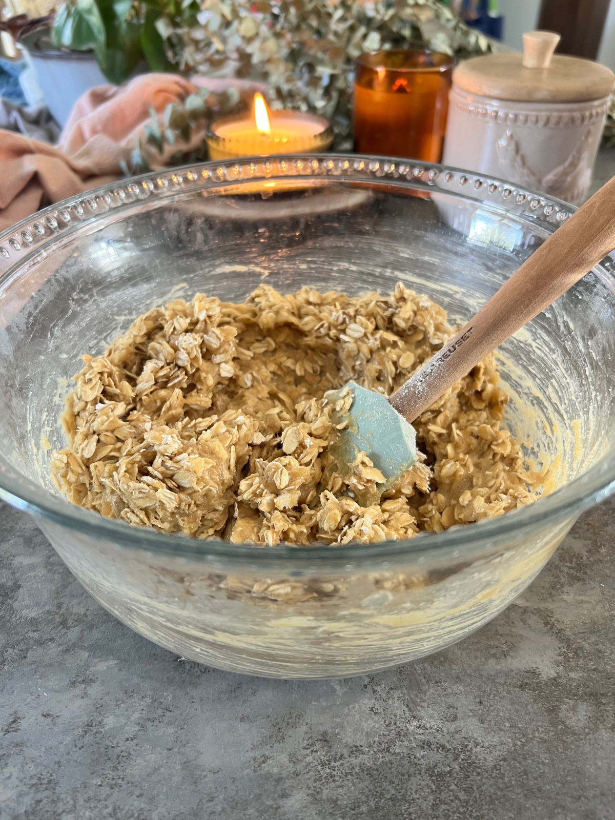 A large mixing bowl sits with the wet ingredients and the oats for the sourdough oatmeal cream pie cookie sandwiches.