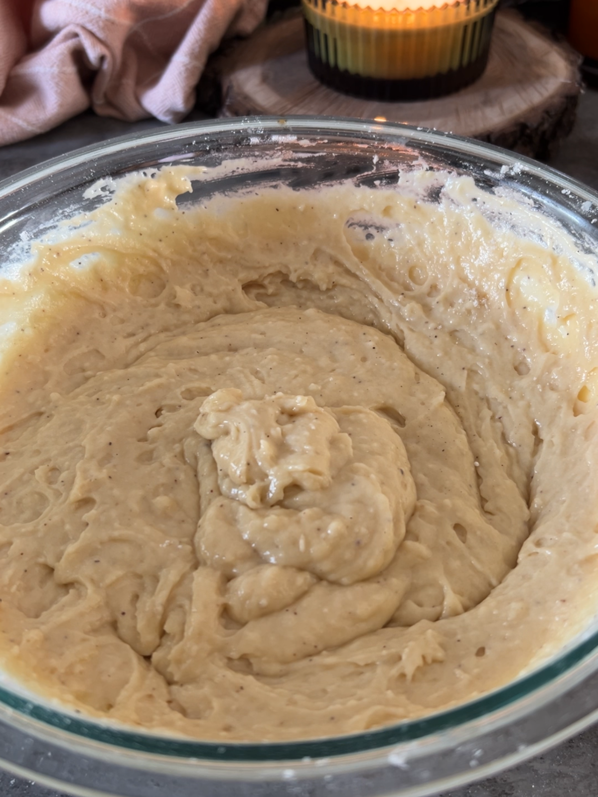 The vanilla bean sourdough discard muffin batter sits in a glass mixing bowl.