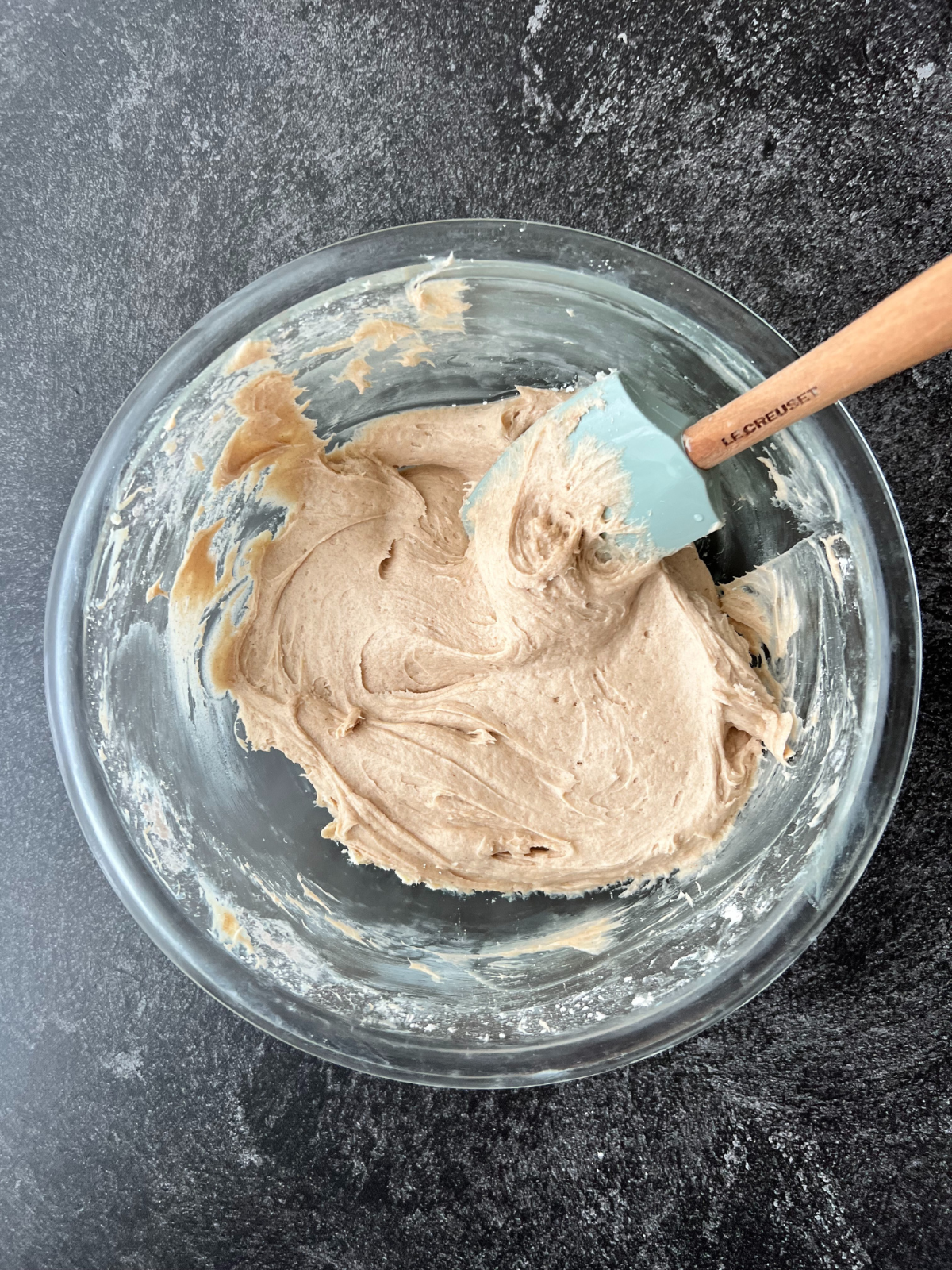 The cinnamon cream cheese frosting sits in a mixing bowl ready to be piped on the sourdough snickerdoodle cupcakes!