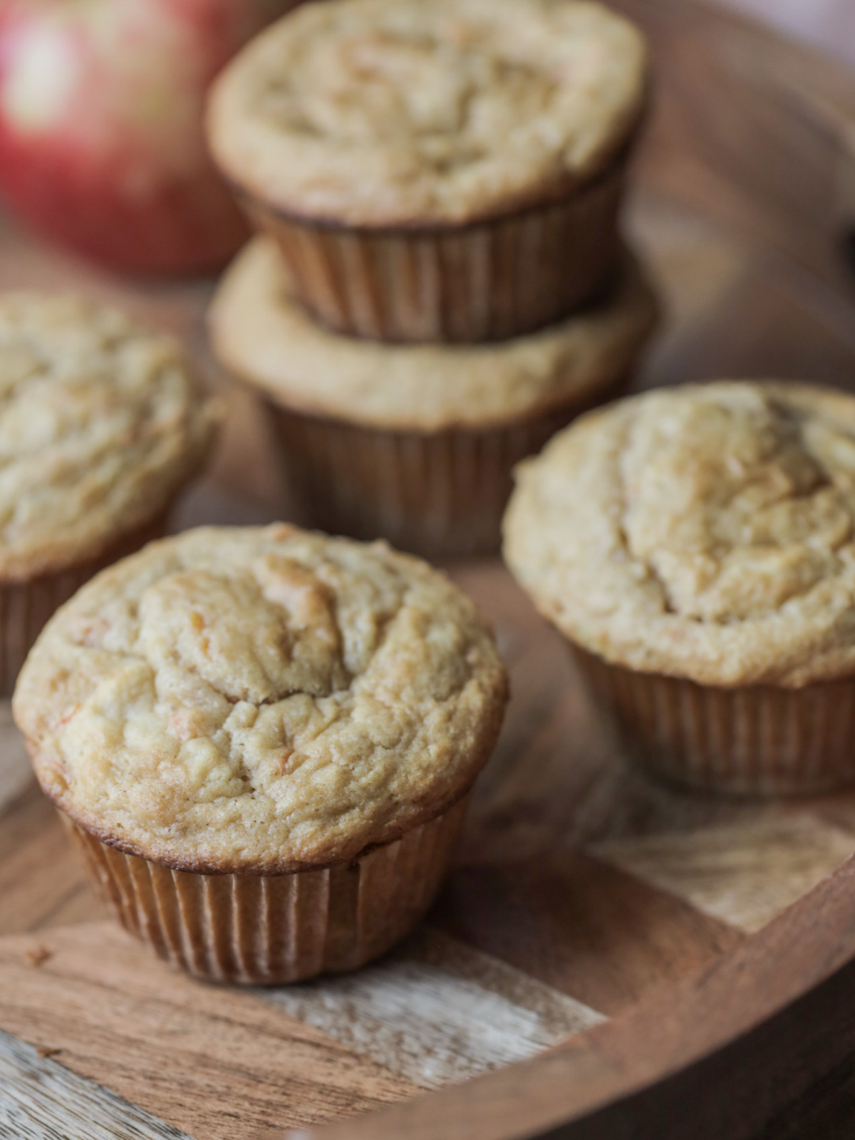 A closeup of one sourdough carrot and apple muffin with others sitting in the background.
