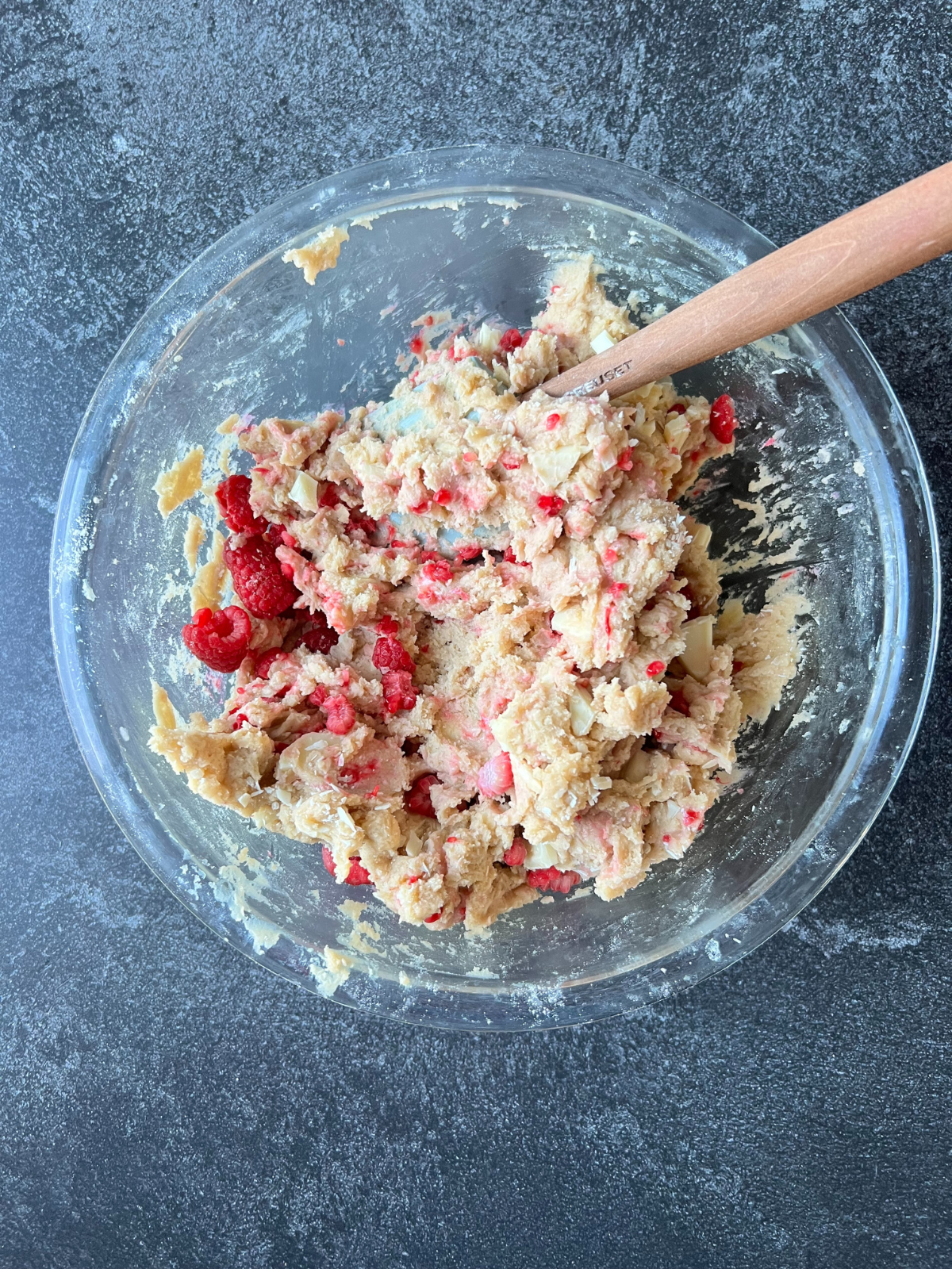 The sourdough discard white chocolate raspberry cookie dough sits in a glass mixing bowl.