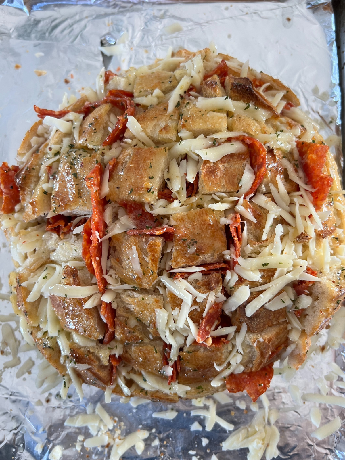 The herby garlic butter has been brushed over the loaf of bread. It's now ready to bake!