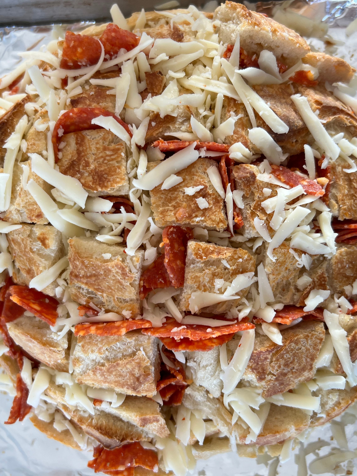 The sourdough bread has been stuffed with pepperonis and shredded mozzarella cheese. 