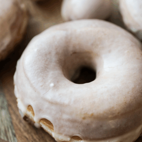 One sourdough glazed donut with several in the background.