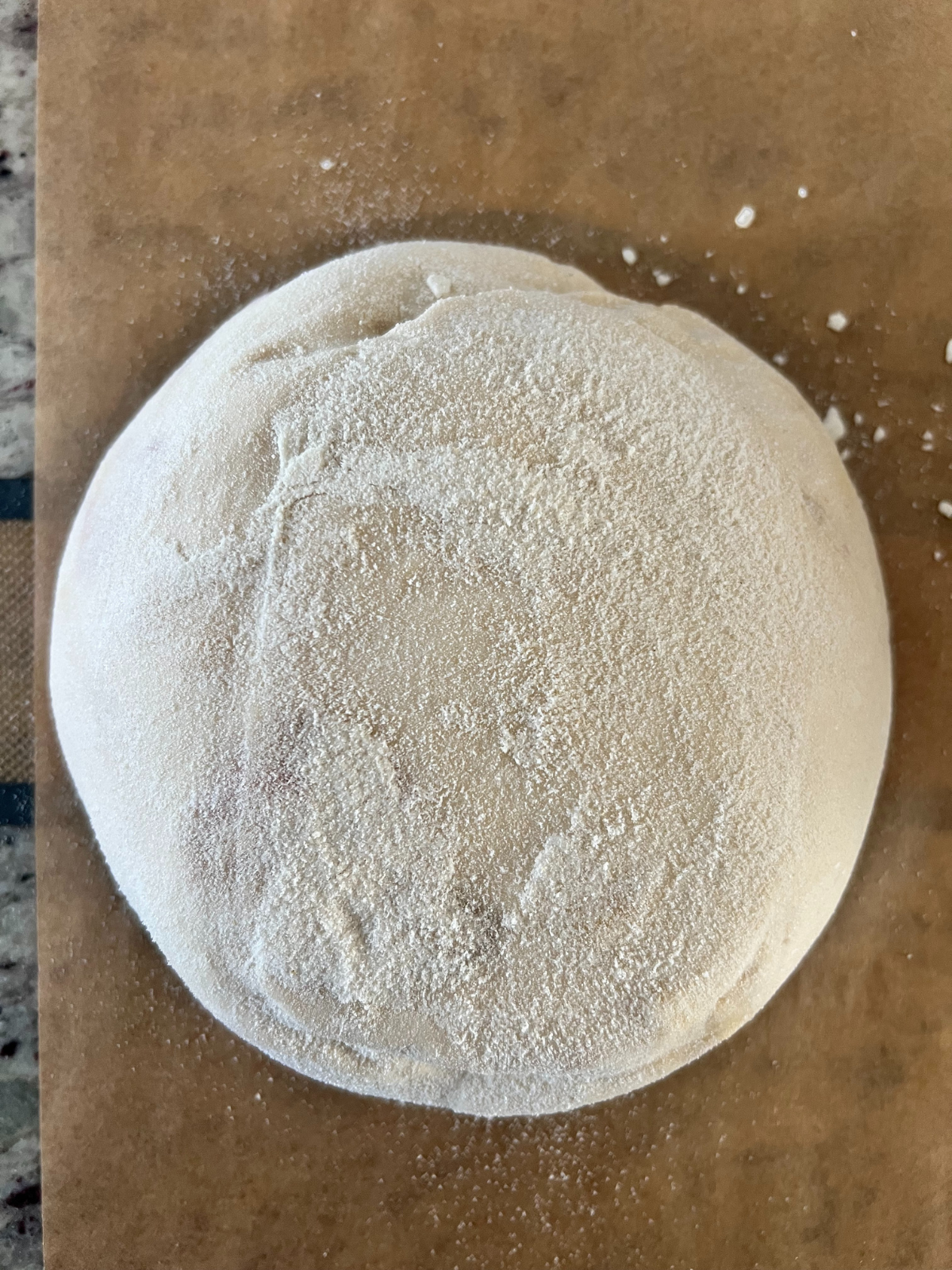 The dough sits on a wooden cutting board after an overnight cold ferment.